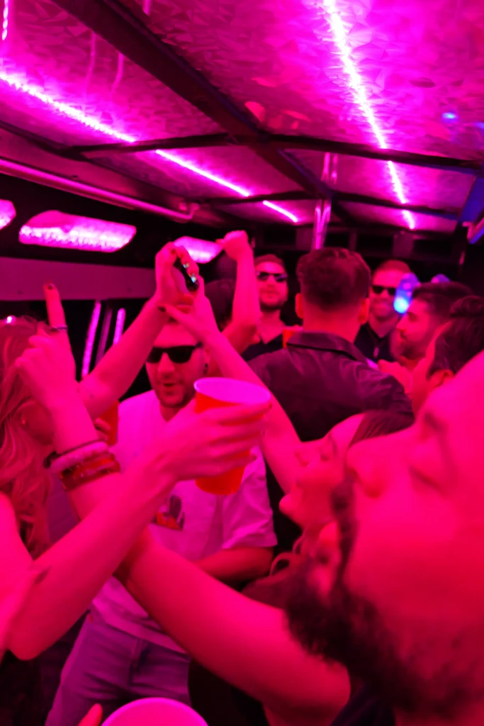 Party bus guests enjoying a night out under pink and purple LED lights