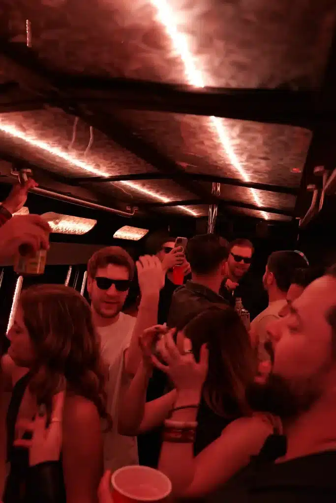 Friends enjoying a ride inside the party bus with red LED lighting