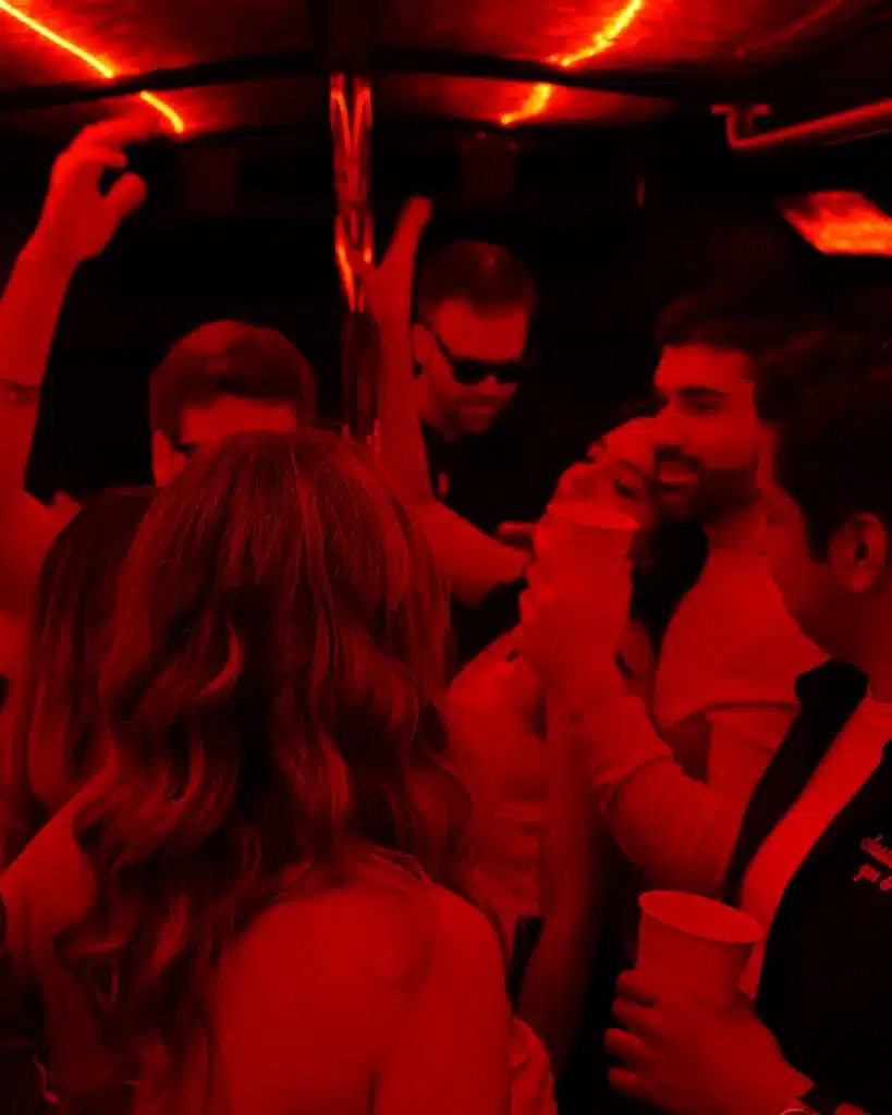 Friends partying inside a Luxus party bus with red LED lights