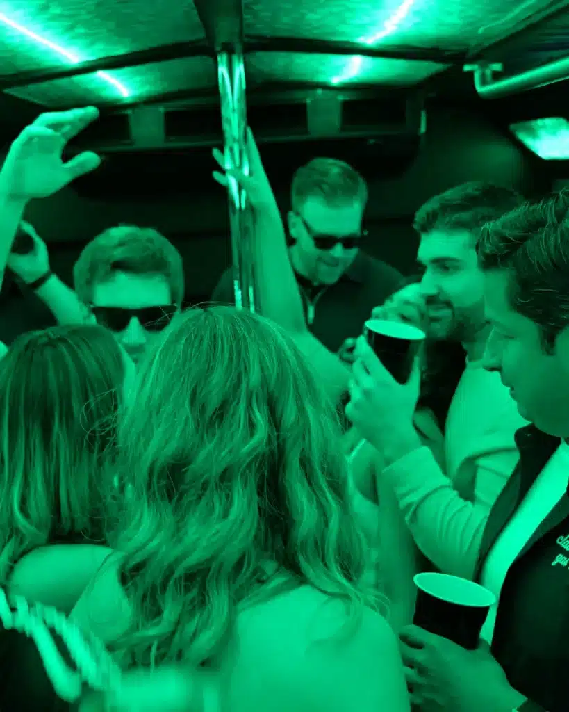 Friends partying inside a Luxus party bus with green LED lights
