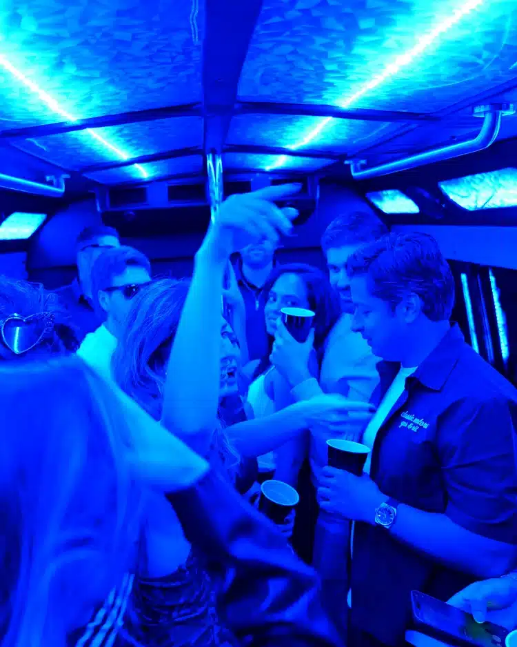 Guests celebrating inside a Luxus party bus with blue LED lights