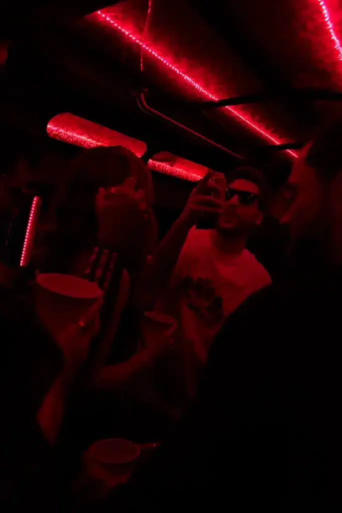Guests inside the Luxus party bus with red LED lighting