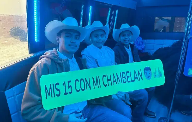 Quinceañera guests in cowboy hats holding a 